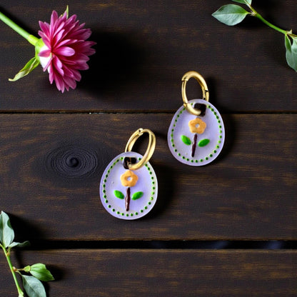 pair of floral oval charms on earrings in round tray