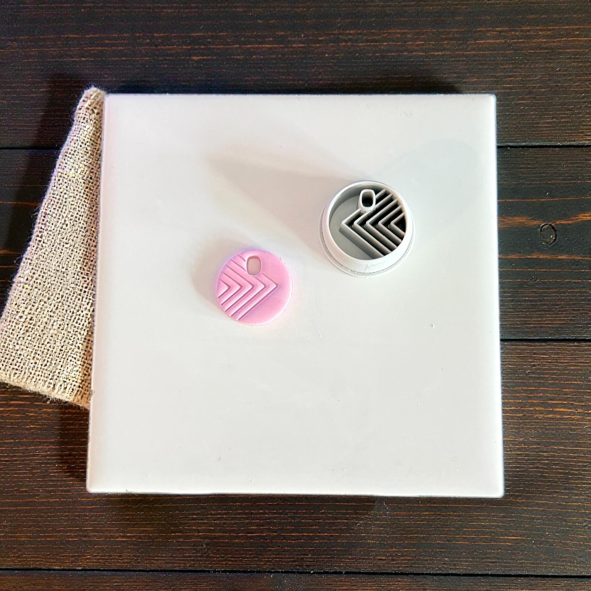 round clay charm and cutter displayed on tile