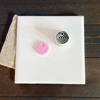 round clay charm and cutter displayed on tile