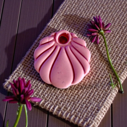 pink scallop charm displayed on burlap surface