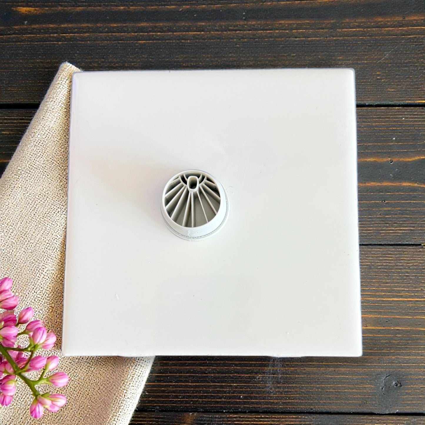 Gray sunburst cutter on white tile