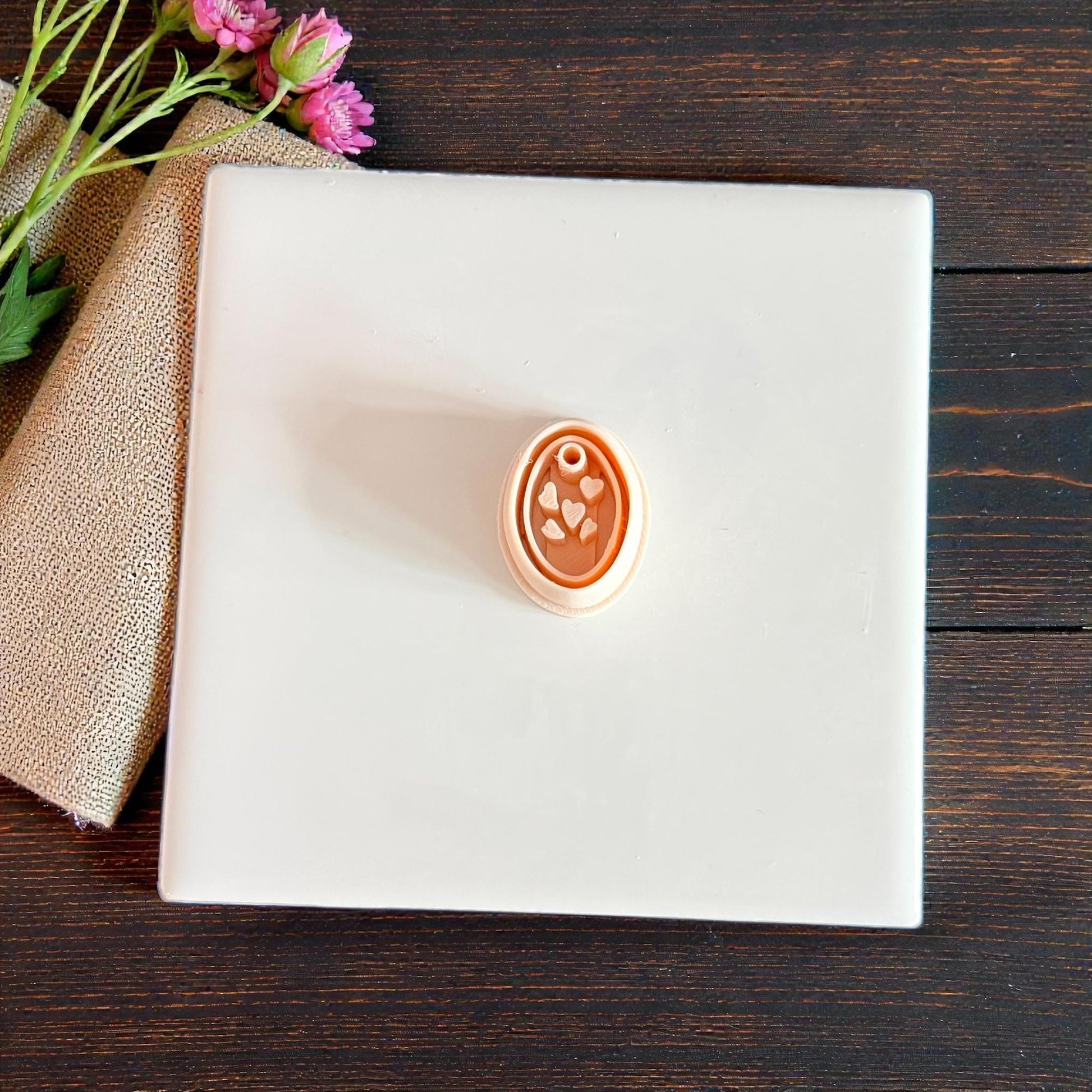 tan oval heart charm cutter on white tile