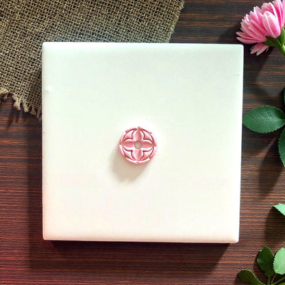 pink round quatrefoil clay impression on burlap