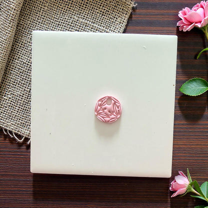 small botanical clay charm on tile