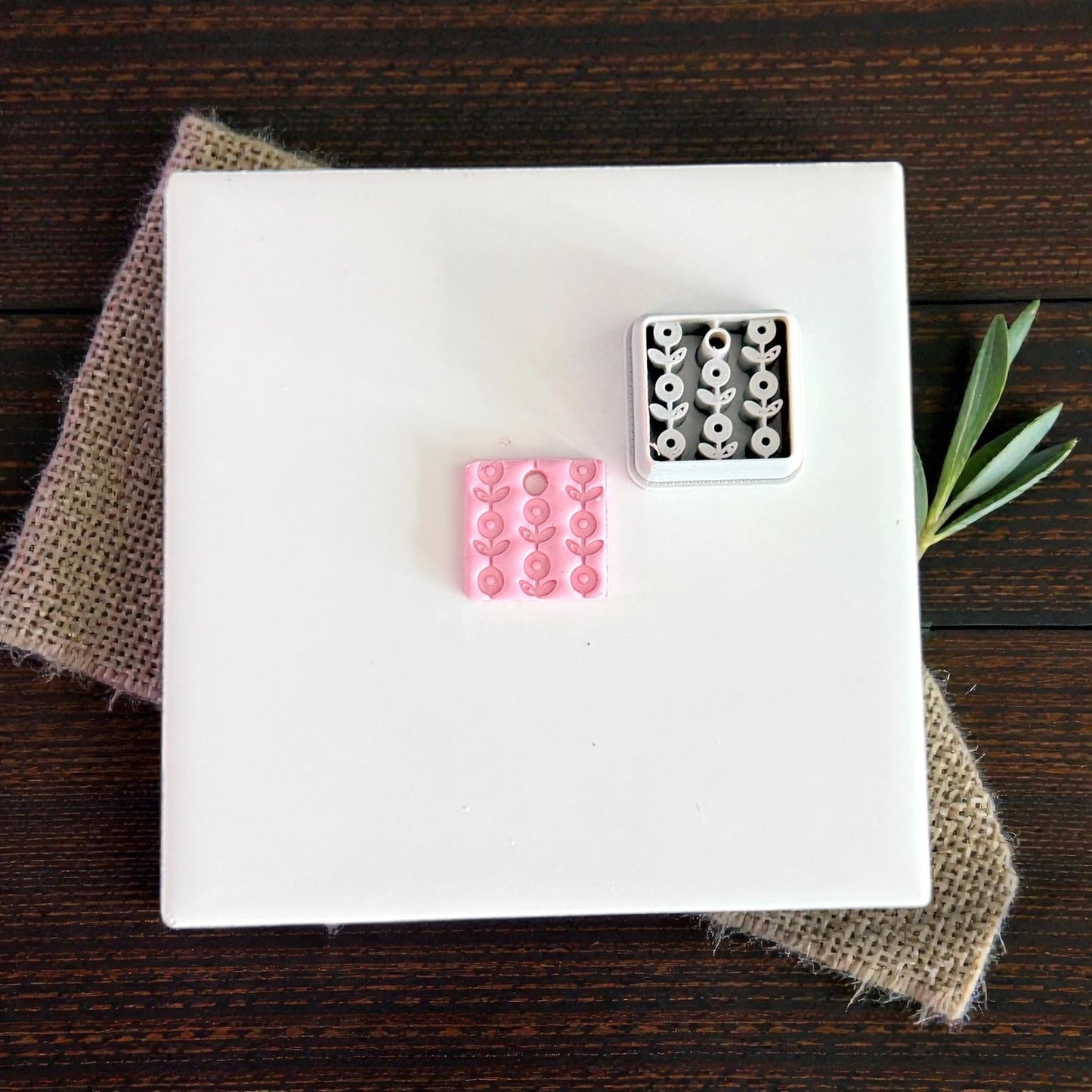 pink and white floral clay charms on white tile