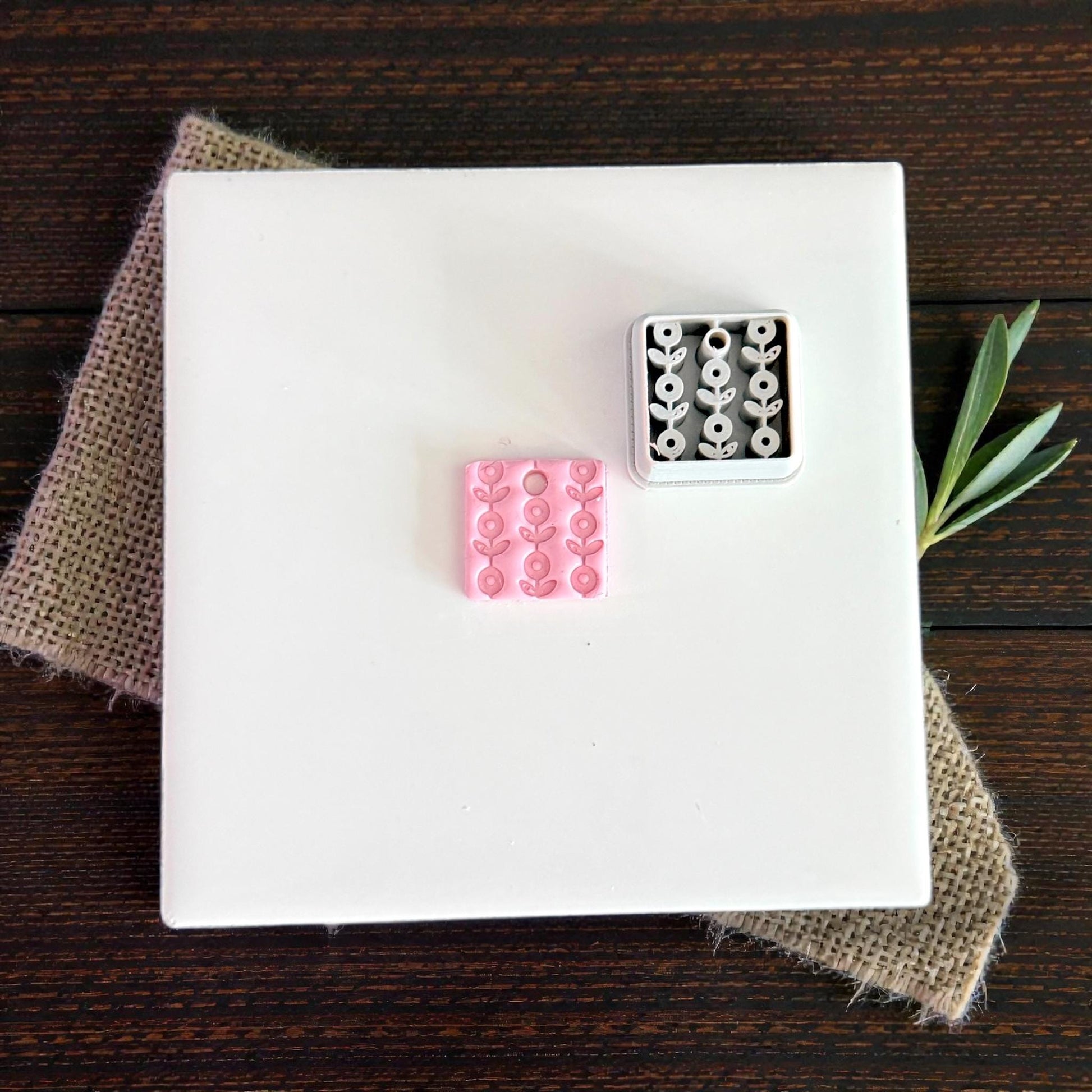 pink and white floral clay charms on white tile