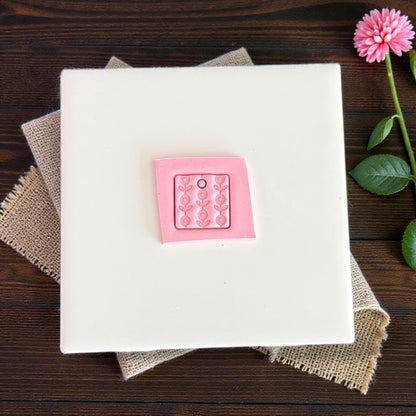 pink floral square clay charm on white tile