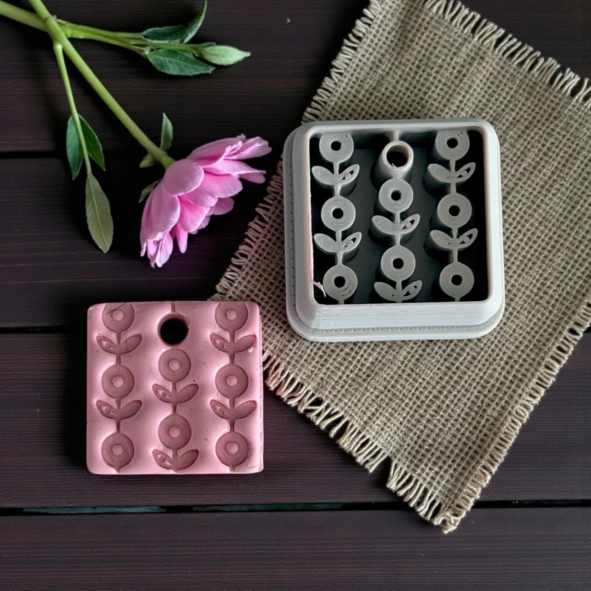 floral clay charm with matching cutter on burlap