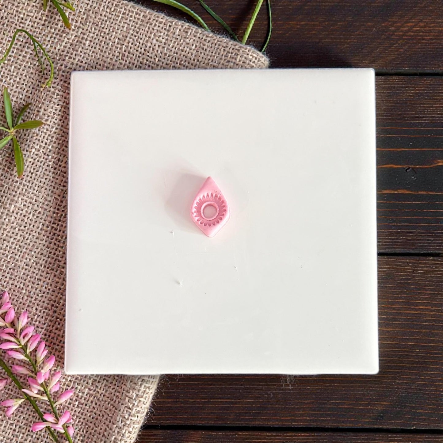 small pink teardrop clay piece on tile