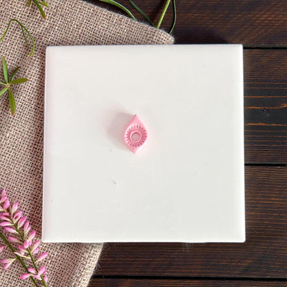 small pink teardrop clay piece on tile