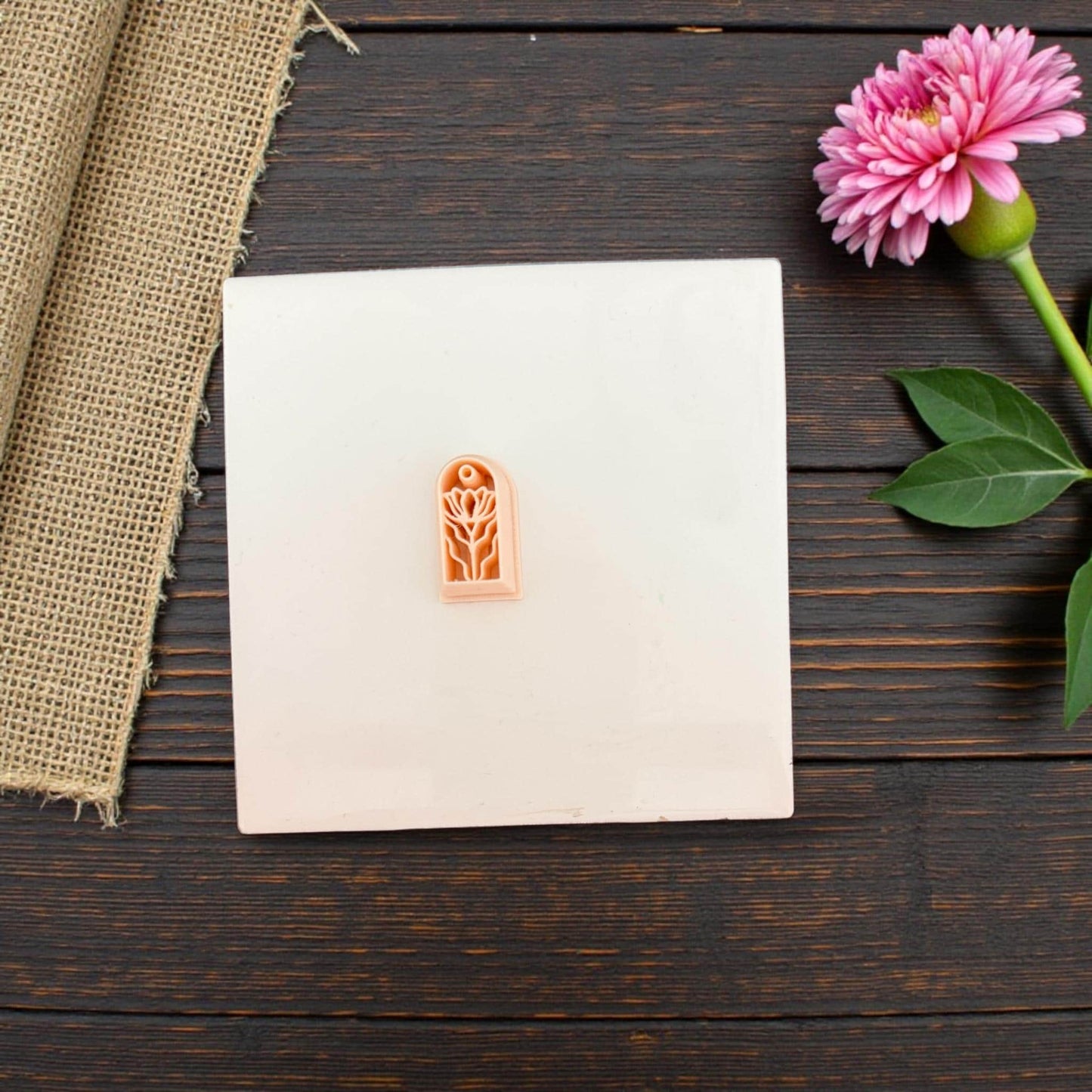 Arched floral polymer clay cutter on white tile