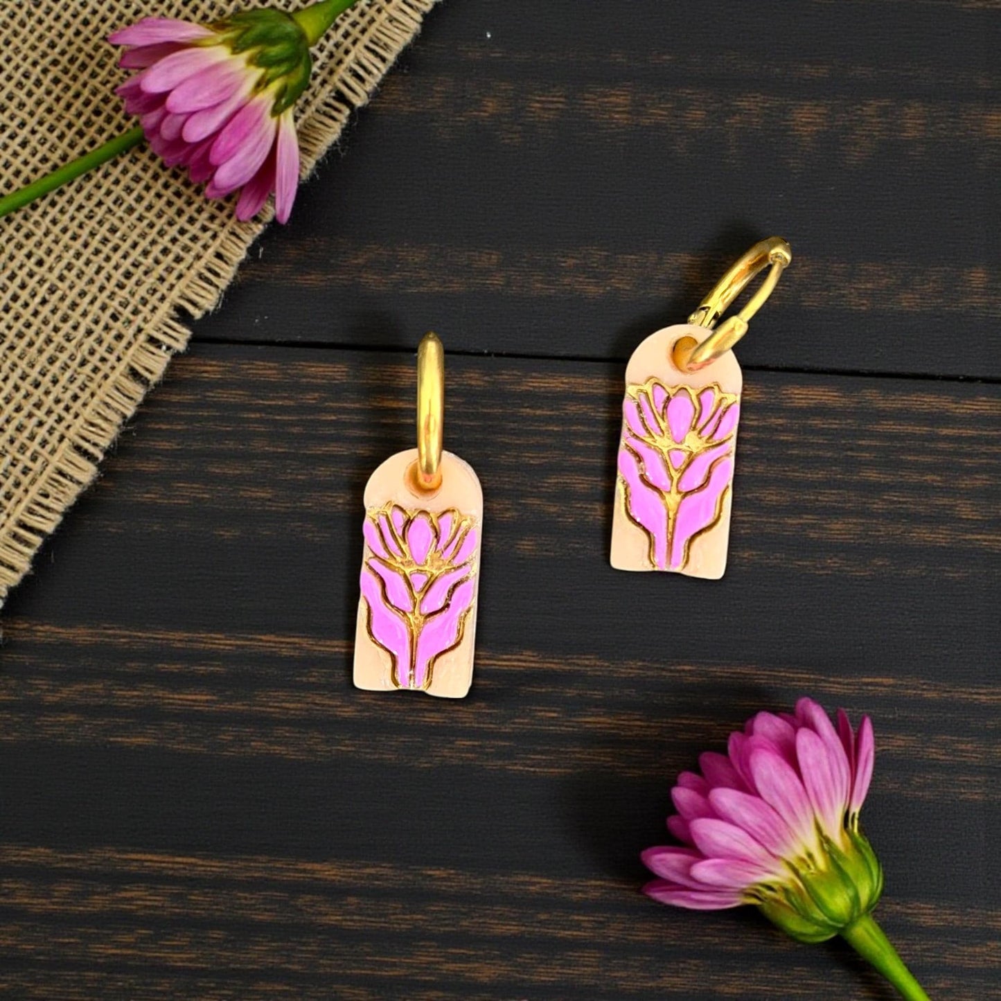 Pink floral charm earrings styled with flowers