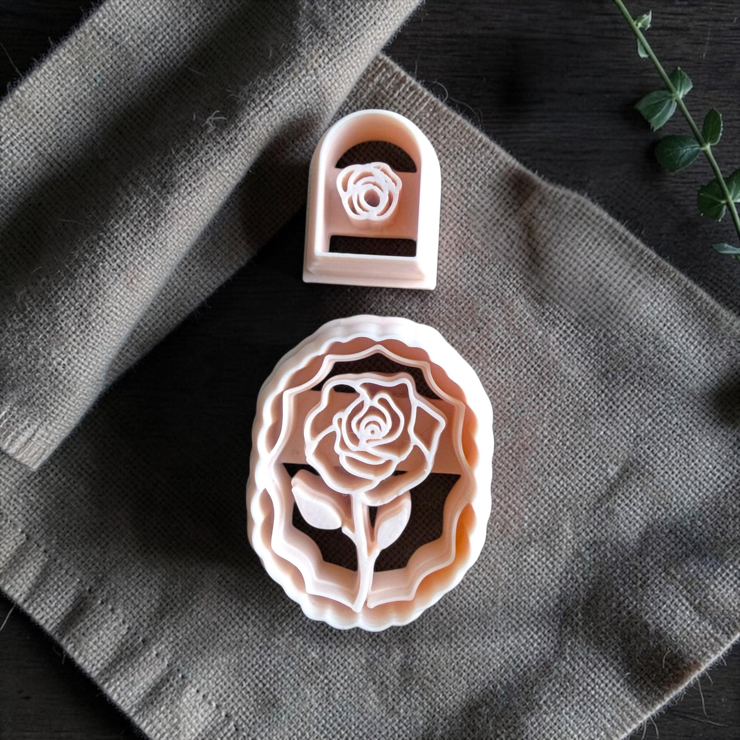 closeup of rose cameo cutter and small rose cutter on linen fabric