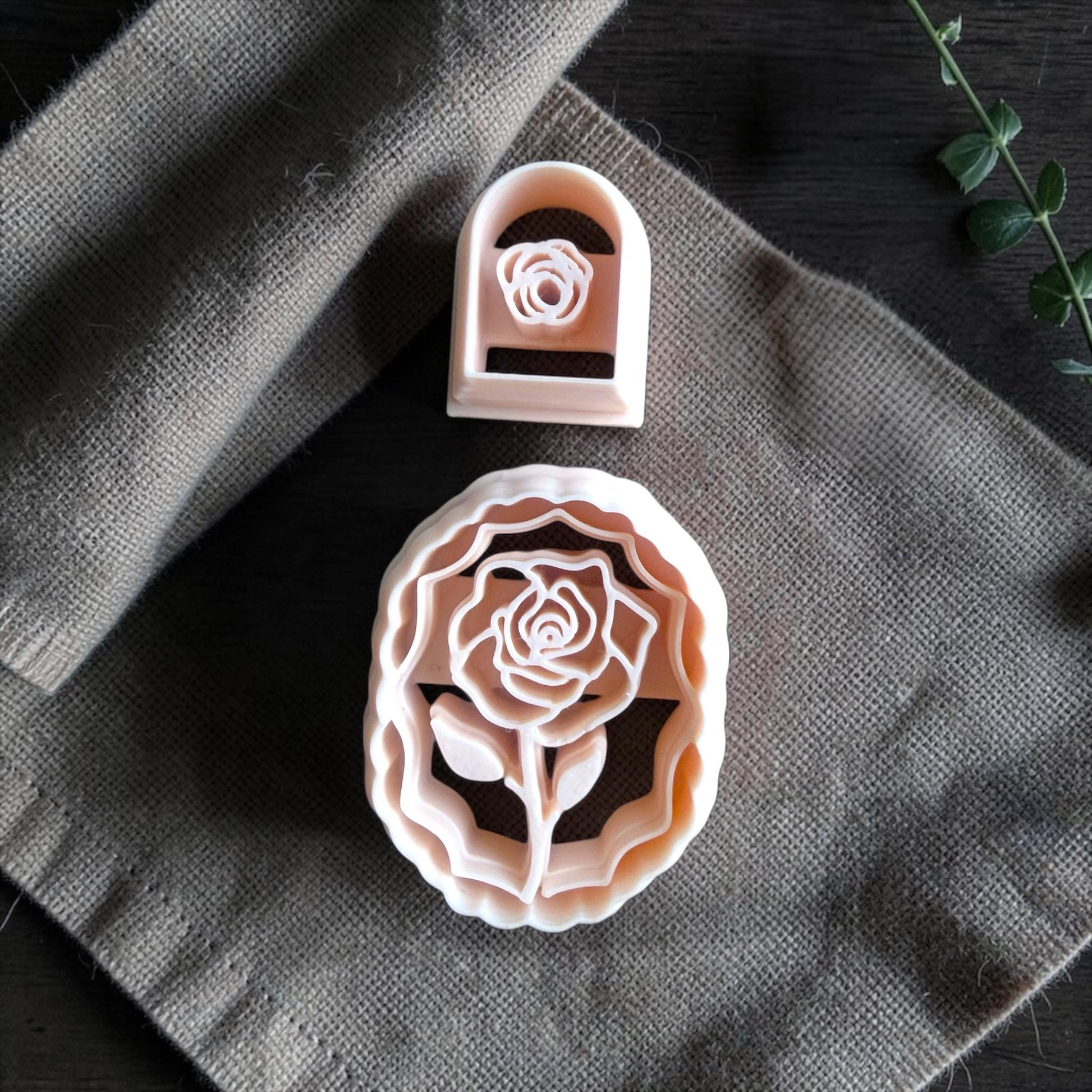 closeup of rose cameo cutter and small rose cutter on linen fabric