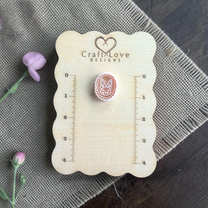 bunny clay imprint beside oval cutter on burlap with flower