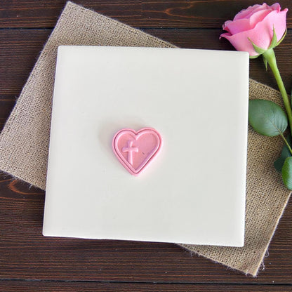 heart cross polymer clay imprint displayed on white tile