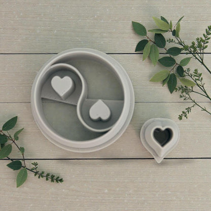 close up yin yang heart cutter and mini heart cutter on wood background