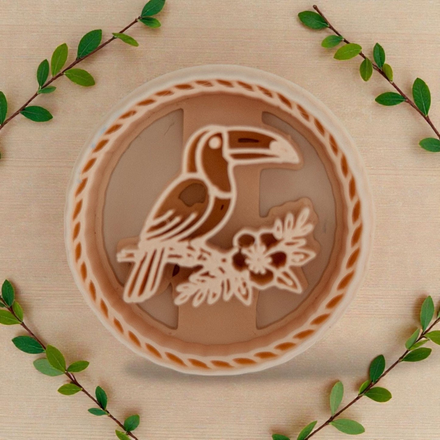 toucan round polymer clay cutter on beige background with greenery