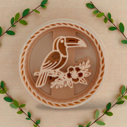 toucan round polymer clay cutter on beige background with greenery