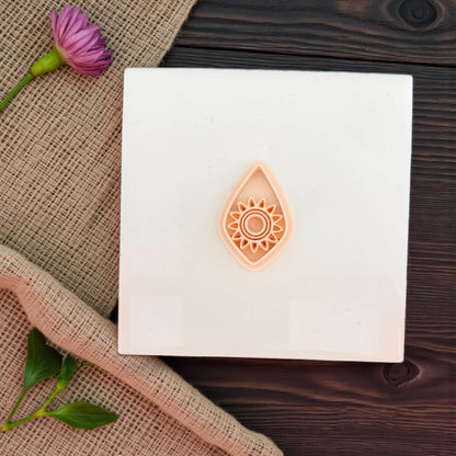 polymer clay cutter teardrop sunburst design on white tile