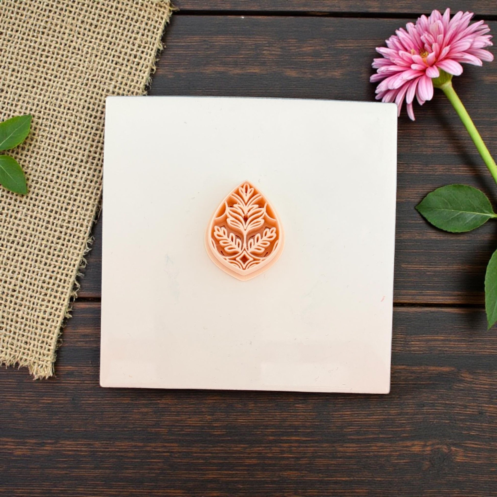 Small teardrop leaf pattern clay cutter displayed on ceramic tile