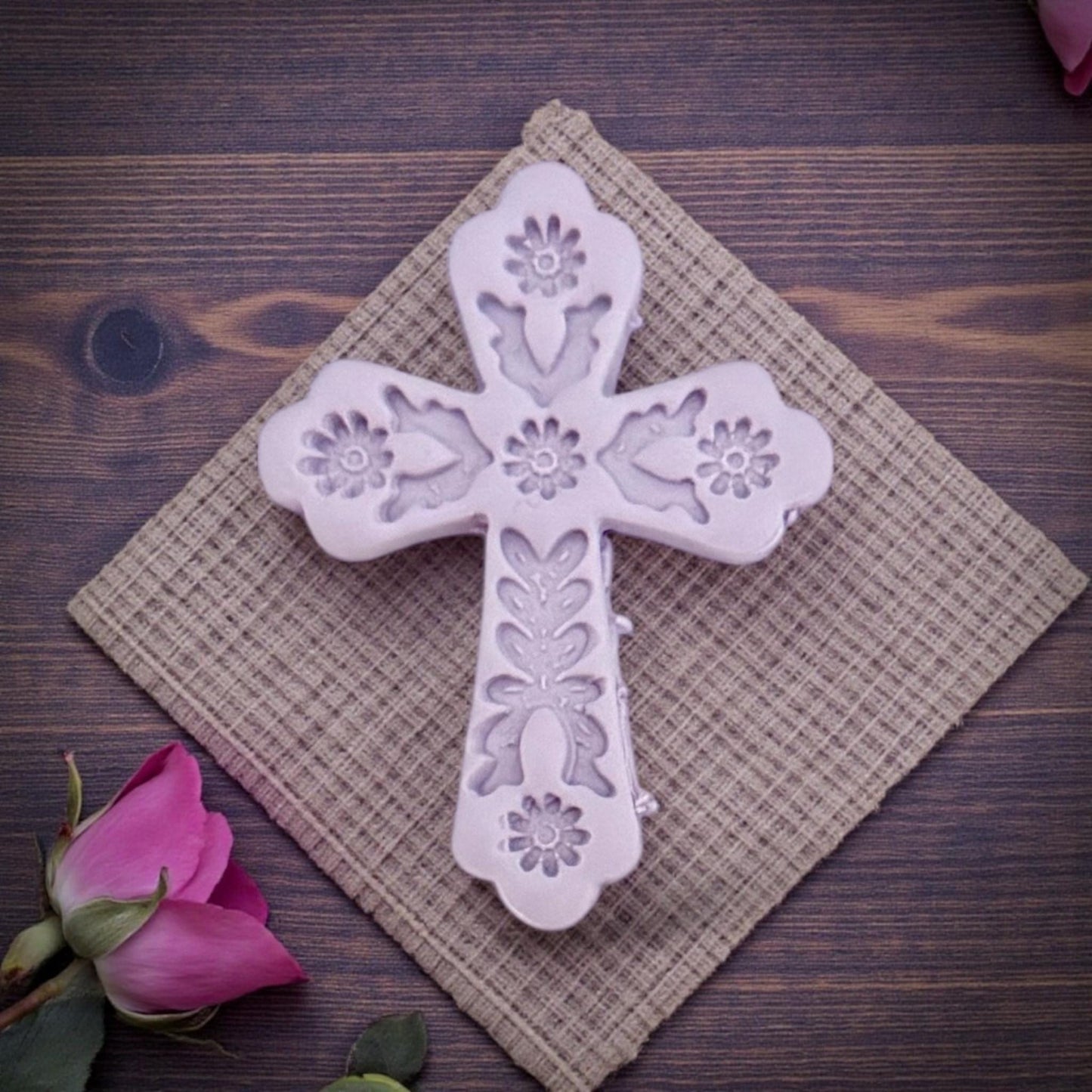 embossed floral cross clay piece on textured cloth