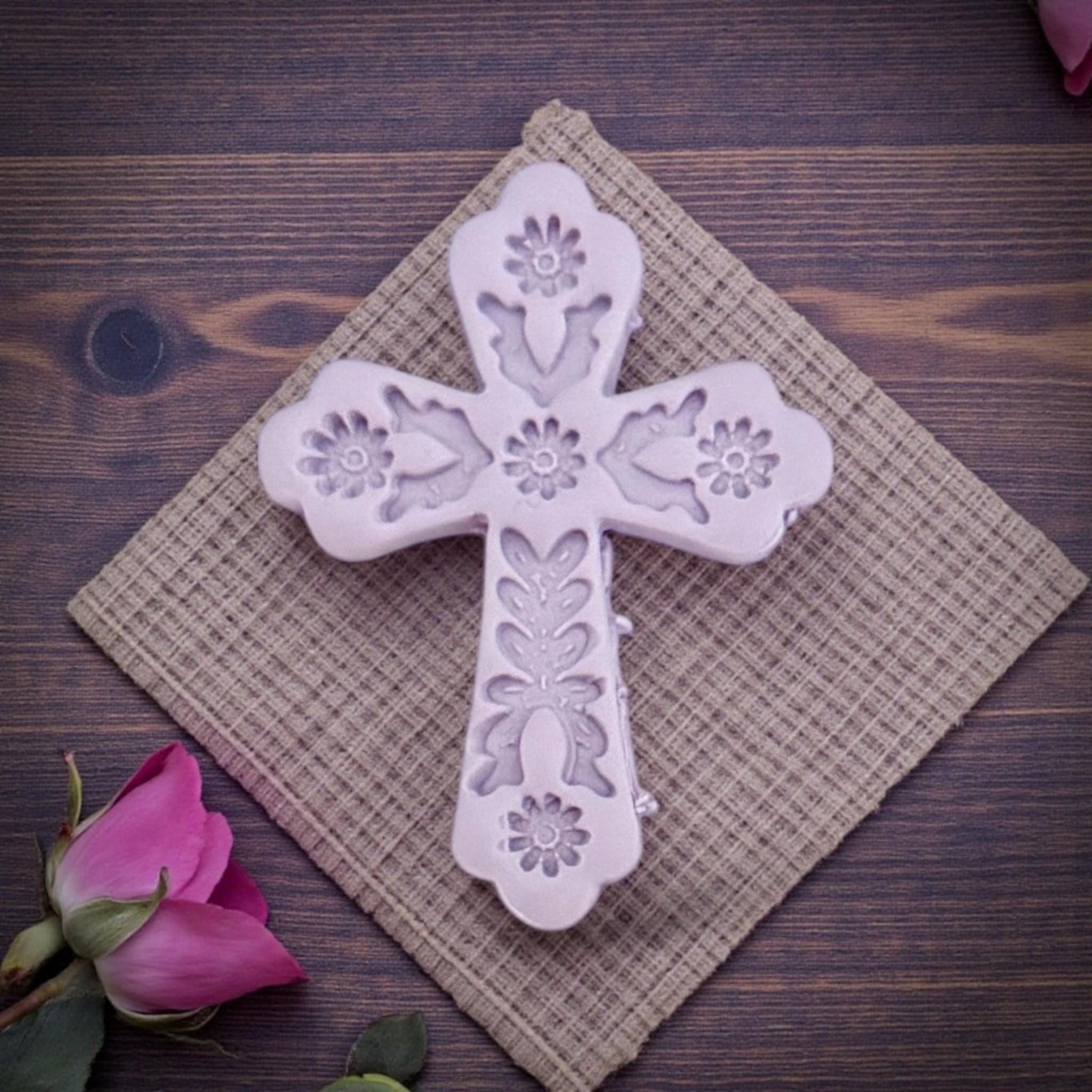 embossed floral cross clay piece on textured cloth