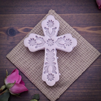 embossed floral cross clay piece on textured cloth