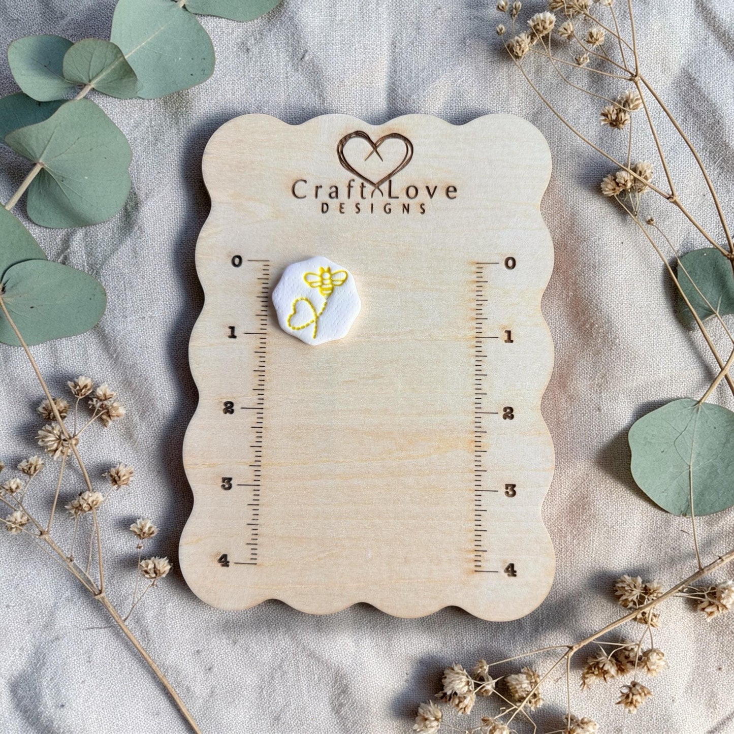 yellow bee stamped clay example on measuring board