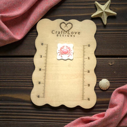 scalloped crab cutter on wooden size board with shells and pink net fabric