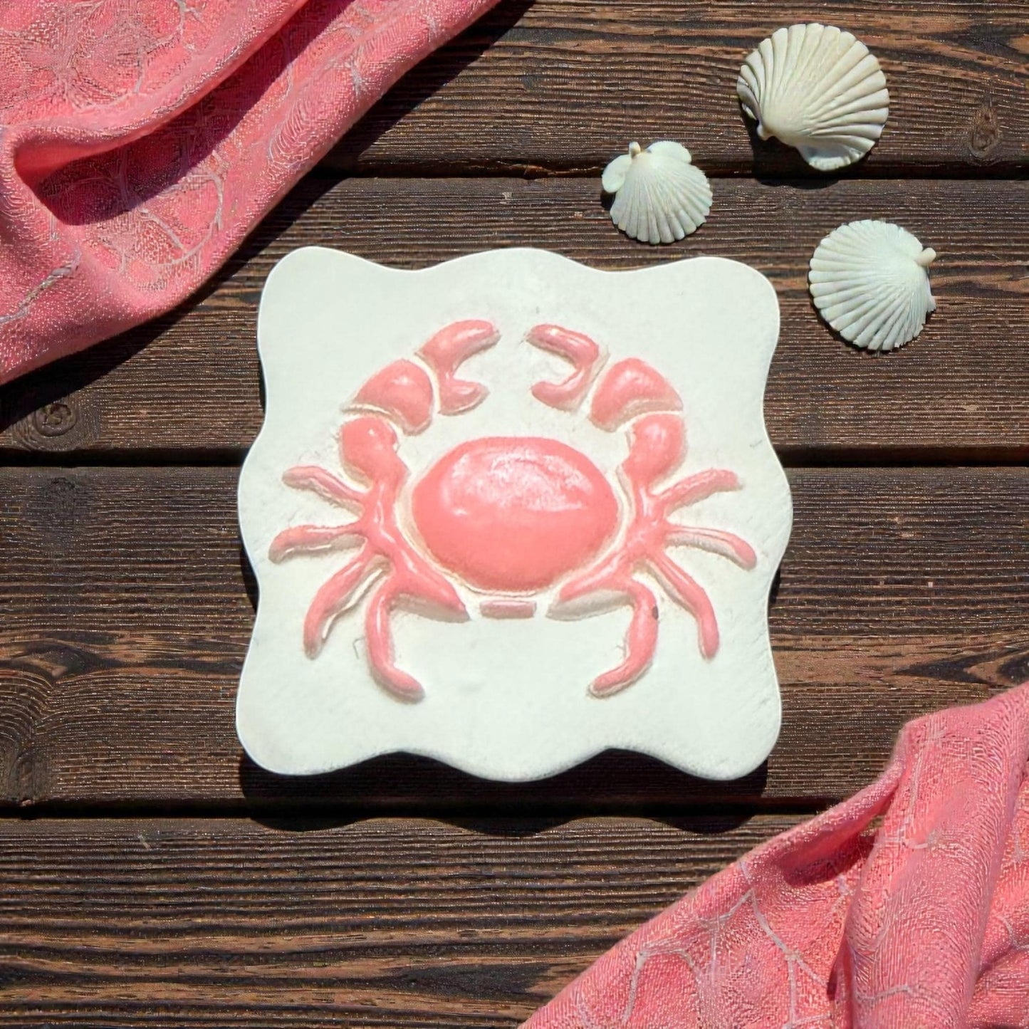 large pink crab imprint on scalloped clay piece with shells