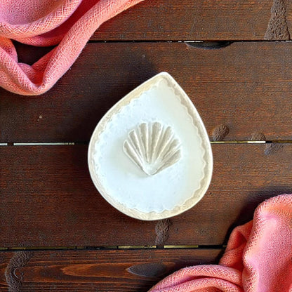 teardrop seashell cutter on wooden size board with shells