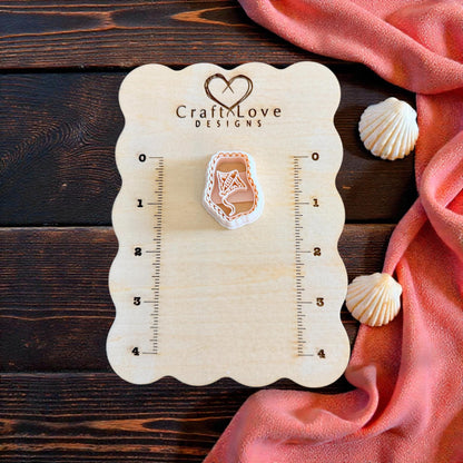 manta ray cutter on wooden measuring board with shells