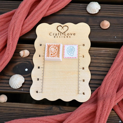 two shell tile pieces shown on wooden board with shells and pink fabric