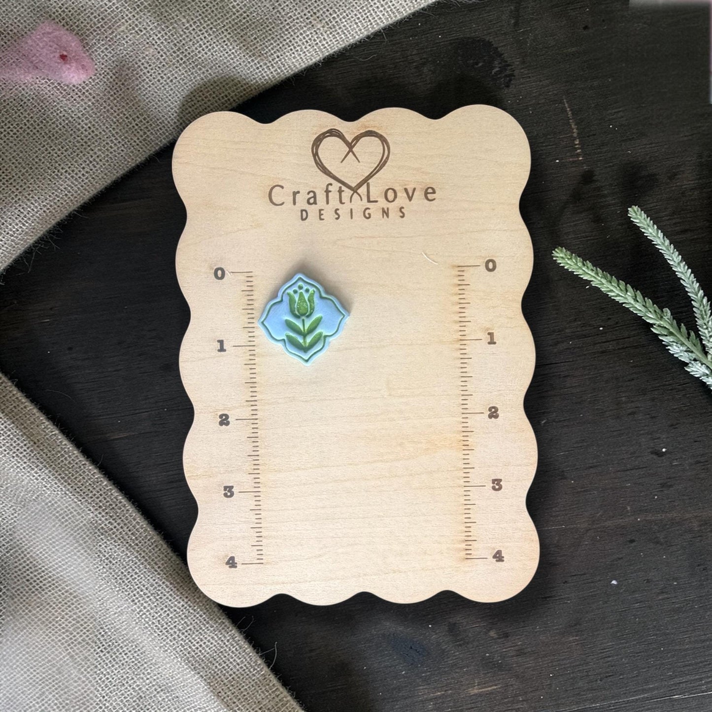 Finished blue clay tulip charm on Craft Love Designs ruler board