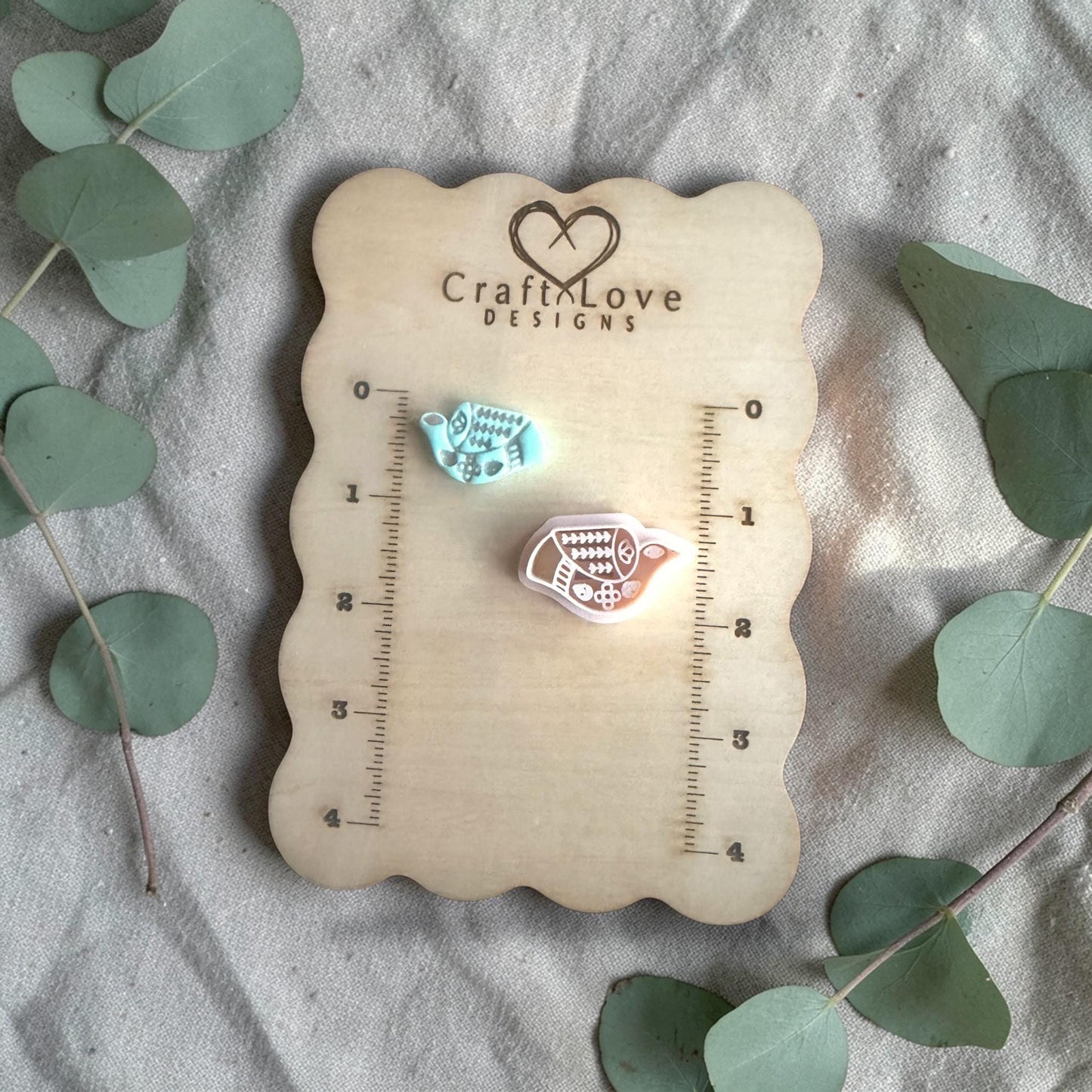 two clay bird charms on Craft Love Designs ruler board showing scale
