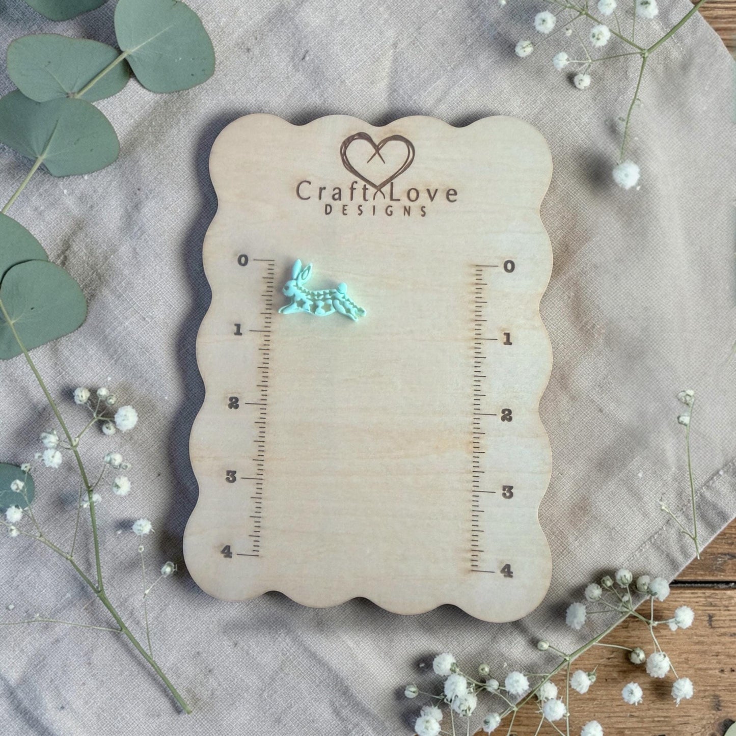 finished turquoise rabbit clay charm displayed on Craft Love Designs ruler board