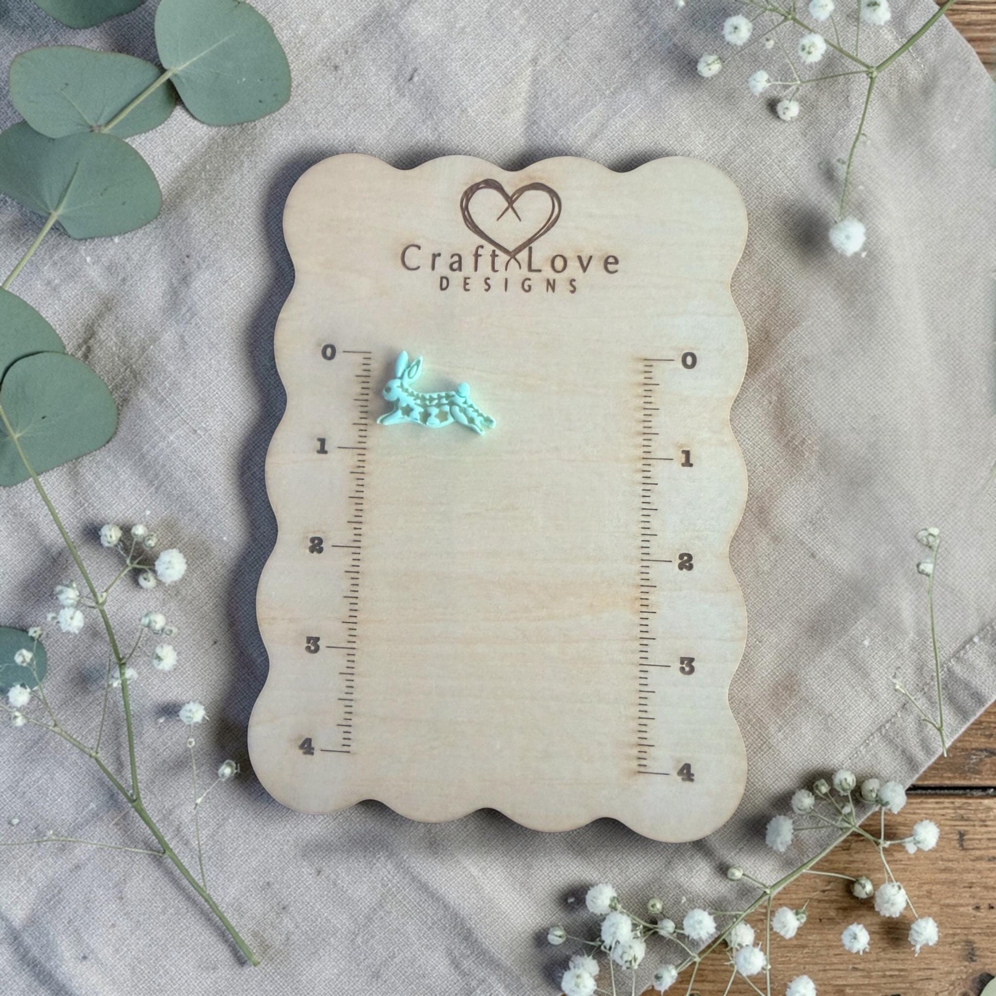 finished turquoise rabbit clay charm displayed on Craft Love Designs ruler board