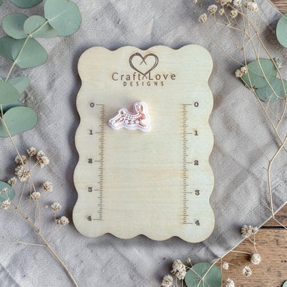 white polymer clay rabbit cutter displayed on Craft Love Designs ruler board