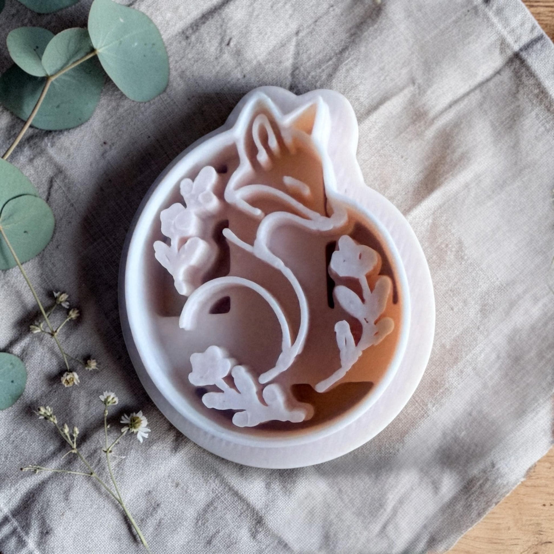 polymer clay fox cutter with floral frame resting on linen fabric