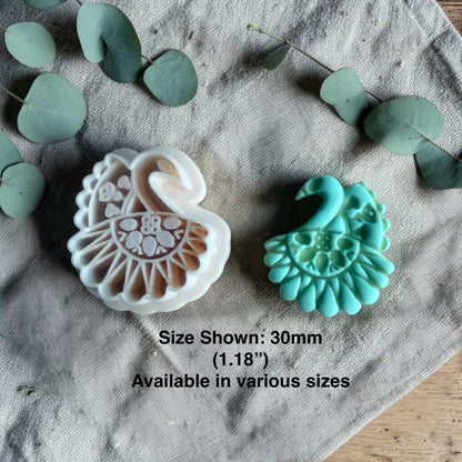 white polymer clay peacock cutter next to turquoise finished clay charm