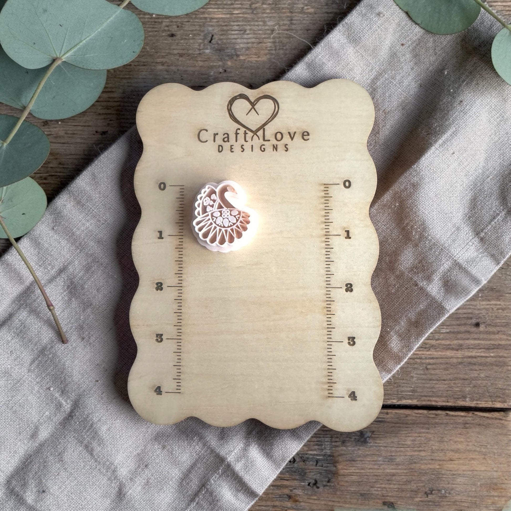 white polymer clay peacock cutter displayed on Craft Love Designs ruler board
