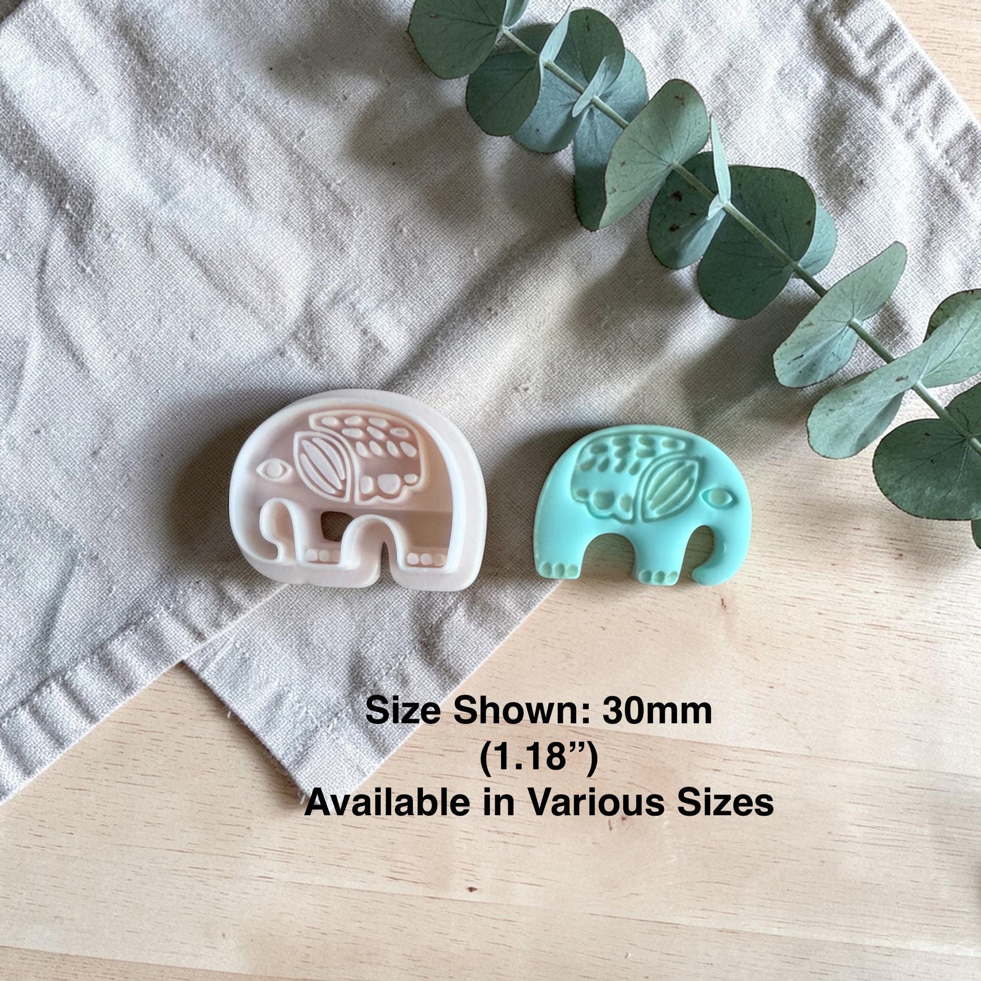 white elephant clay cutter beside finished turquoise elephant charm with size text