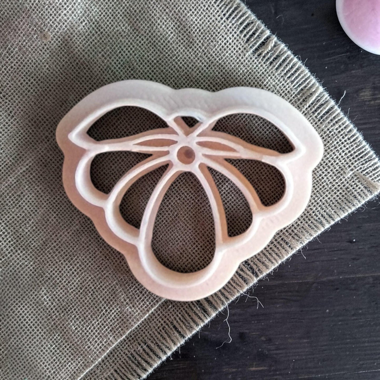 white petal flower polymer clay cutter on burlap fabric