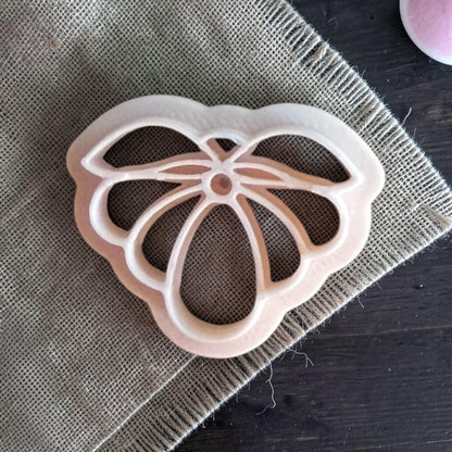 white petal flower polymer clay cutter on burlap fabric