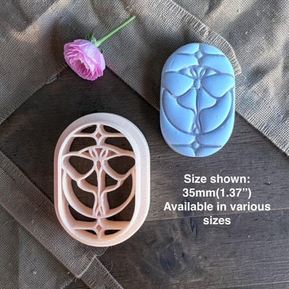 Butterfly clay cutter next to the finished stained glass clay piece.