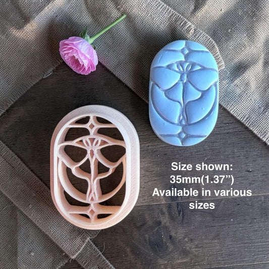 Butterfly clay cutter next to the finished stained glass clay piece.