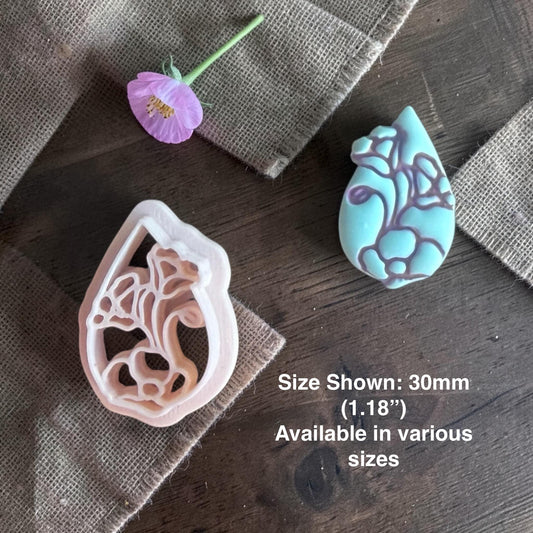 Teardrop flower clay cutter next to finished clay piece.