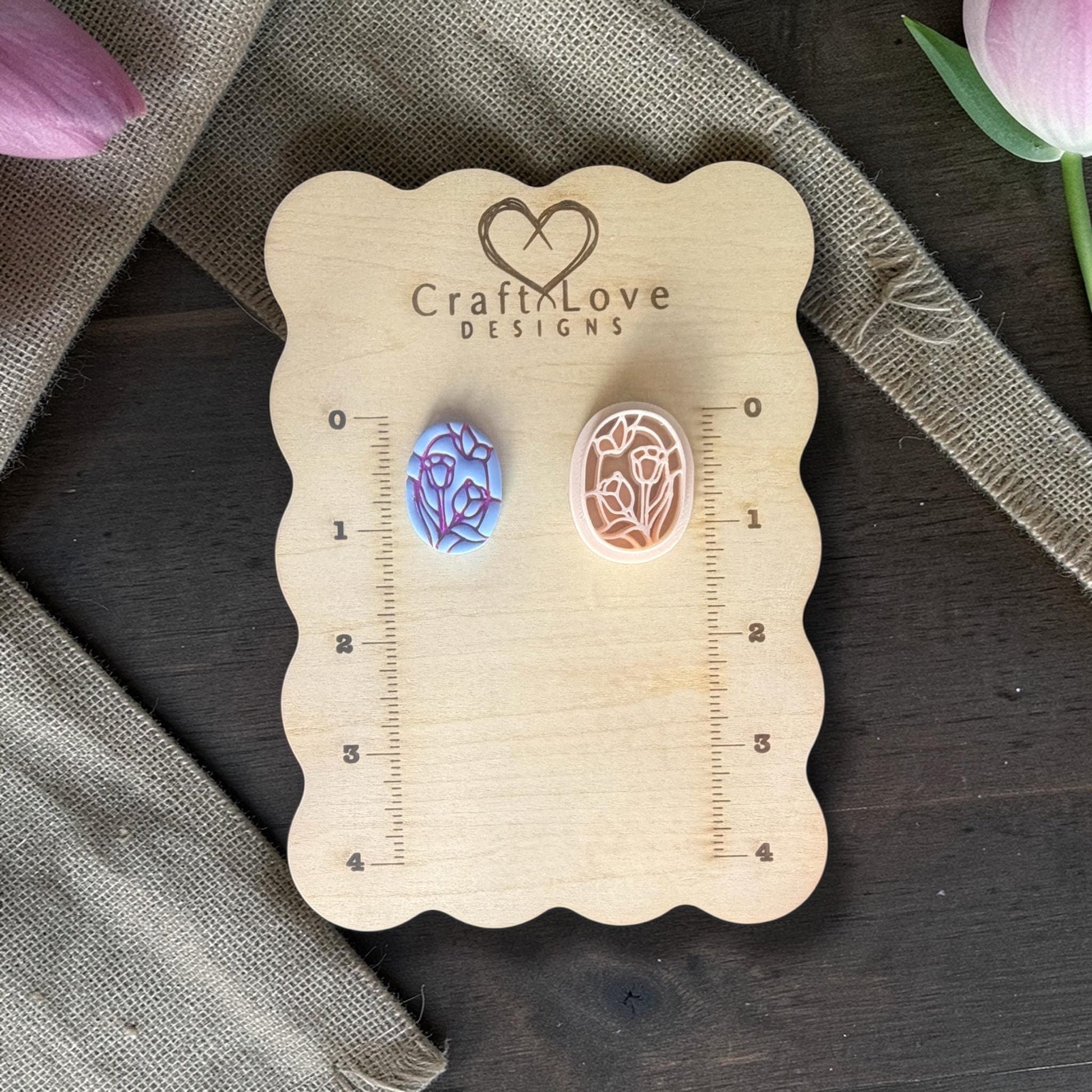Tulips and butterfly clay cutter next to finished clay piece.