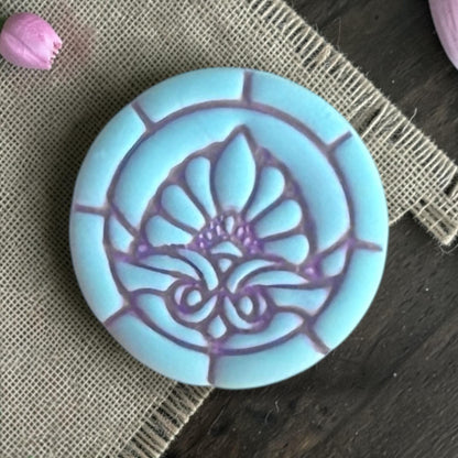 Close up of stained glass floral clay piece.